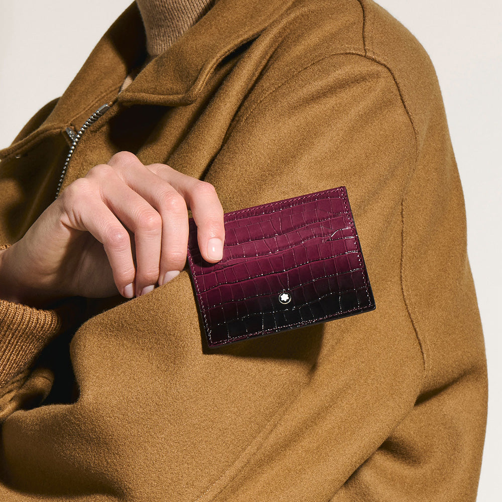 An everyday companion, this croco-embossed card holder has a compact silhouette that fits neatly into most pockets. Crafted in cassis leather, it comes with space for up to six credit cards and it features an additional pocket for small belongings. Material : Leather Leather : Natural calfskin with croco print and sfumato effect Color : Sfumato Cassis with croco-embossed Lining : Textile 6 credit card slots, 1 additional pocket Dimensions : 100 x 5 x 80 mm Country of Origin : Italy